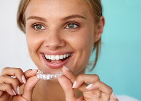 A woman holding a take-home teeth whitening tray