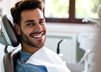 a patient smiling while sitting in the dentist's chair