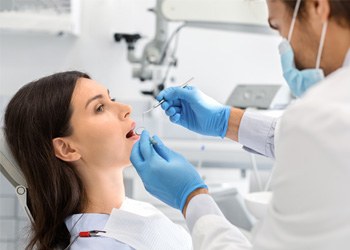 Dentist looking in a patient’s mouth
