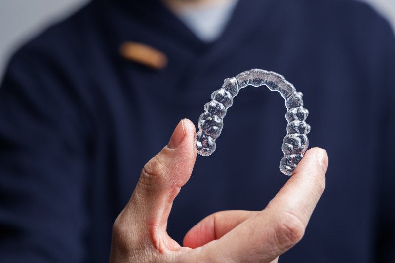 A man holding a ClearCorrect aligner in front of his chest